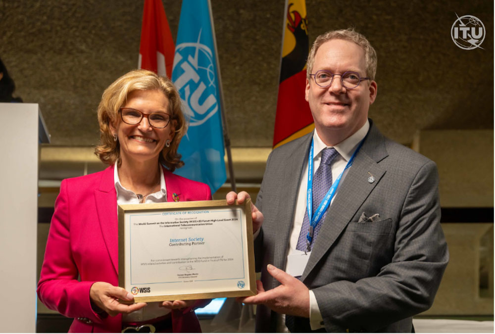 A woman and a man stand side by side while holding a certificate.