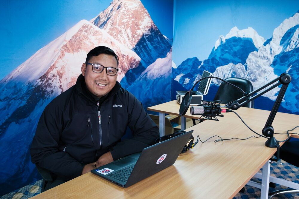 a man in a winter jacket sitting in a computer room