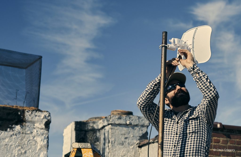 Un hombre instalando una antena.