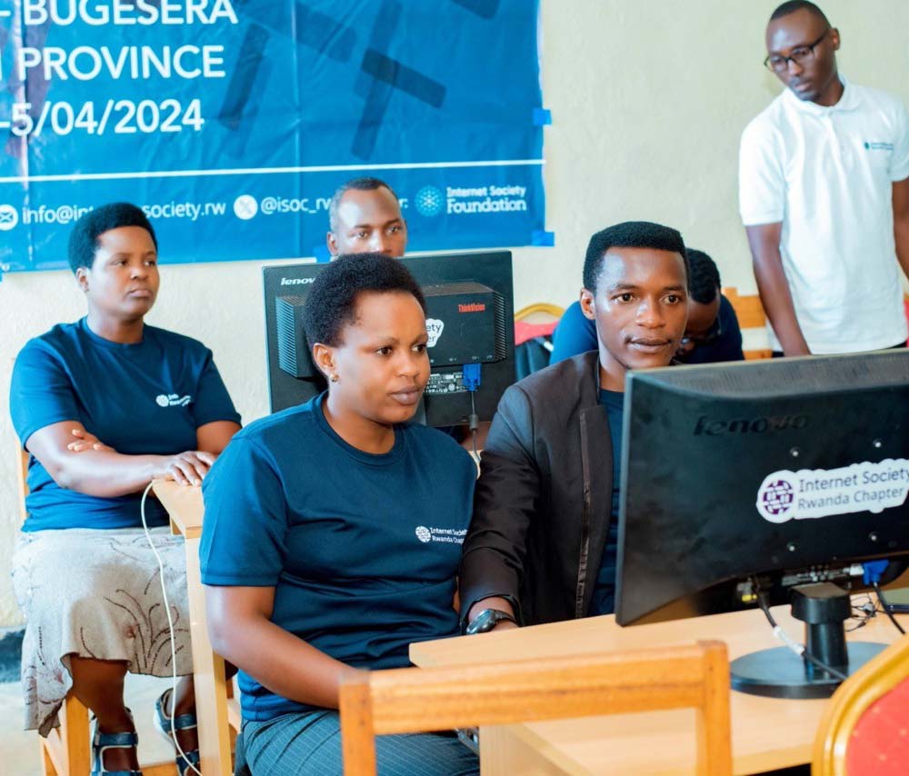 A group of adults sit at computers.