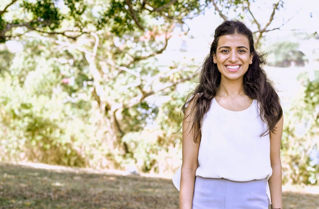 une fille aux cheveux longs souriant en posant pour une photo à l'extérieur