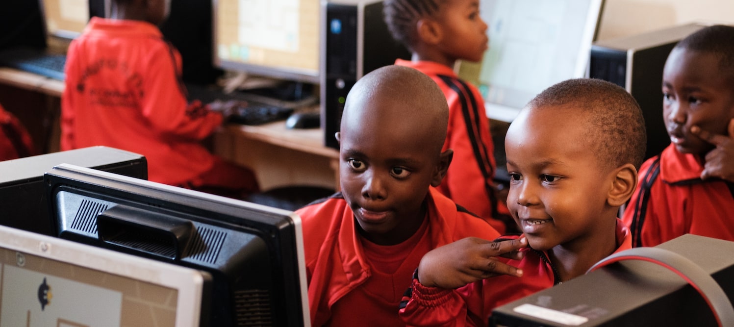 kids looking at computer screen smiling