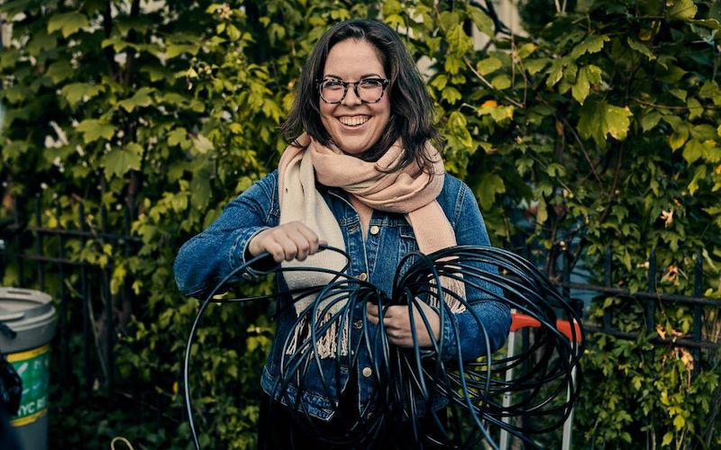 une femme qui tient des câbles en souriant