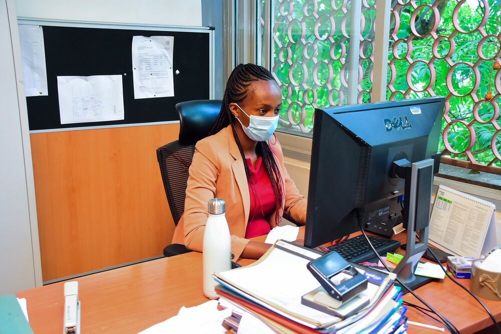 Woman wearing mask and working on a computer