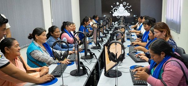 un grupo de mujeres navegantes en Internet en una inmensa sala de conferencias