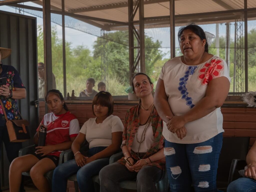 A woman confidently addressing a group of people, standing tall