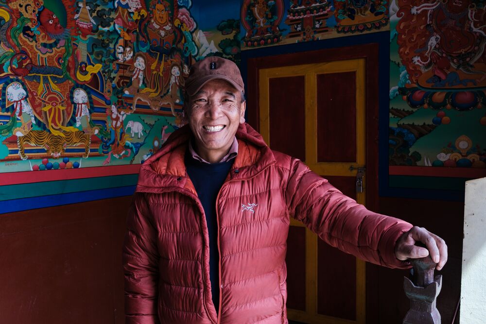 a man smiling at camera in a buddhist monastery