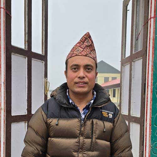 Photo of a man standing in front of an open window.