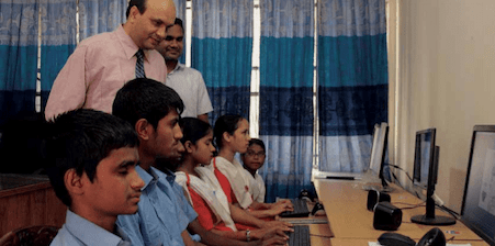 Boys and girls in front of computers working